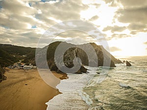 Aerial view from a sandy beach at the sunset with an amazing cliff