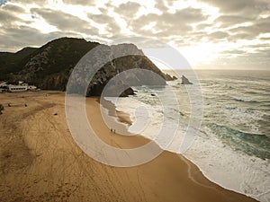 Aerial view from a sandy beach at the sunset with an amazing cliff