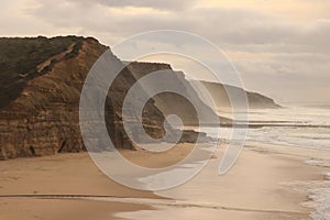 Aerial view from a sandy beach at the sunset with an amazing cliff