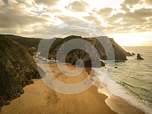 Aerial view from a sandy beach at the sunset with an amazing cliff