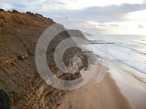 Aerial view from a sandy beach at the sunset with an amazing cliff