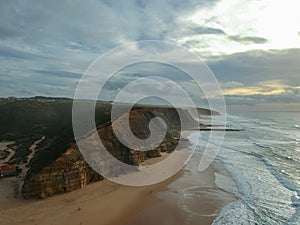 Aerial view from a sandy beach at the sunset with an amazing cliff