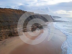 Aerial view from a sandy beach at the sunset with an amazing cliff