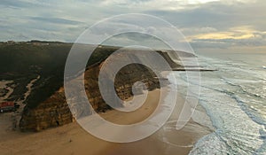 Aerial view from a sandy beach at the sunset with an amazing cliff