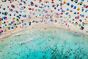 Aerial view of sandy beach with umbrellas and sea