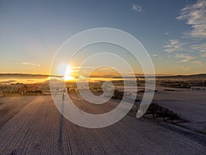 Aerial view of Santa Maria degli Angeli town at sunset, with meadows covered by snow