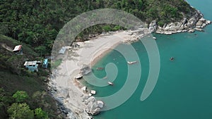 Aerial view of scenery beach. Travel to wild jungles of Thailand. Sea waves leak white sand. Palm trees pass below the