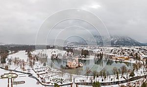 Aerial view of Schloss Anif castle moated in artificial pond Salzburg outskirts in snow in winter view of untersberg