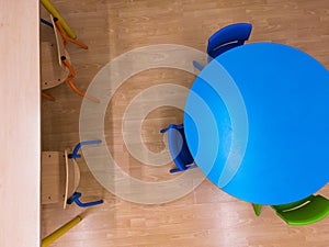 Aerial view of a school classroom, with brown and colored chairs and tables