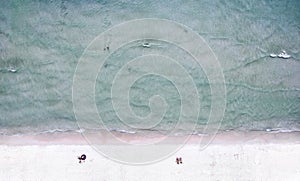 Aerial view of a sea beach on a sunny day and vacationed people.