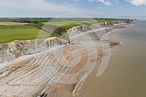 Aerial view of sea cliffs, rock formations and a sandy beach Southerndown, Wales, UK