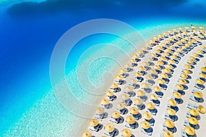 Aerial view of sea, empty sandy beach with sunbeds and umbrellas