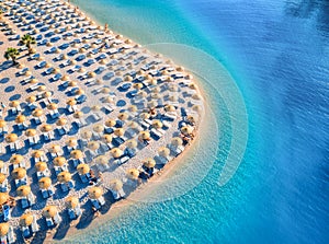 Aerial view of sea, empty sandy beach with sunbeds and umbrellas