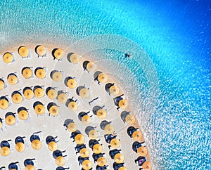 Aerial view of sea, empty sandy beach with sunbeds and umbrellas