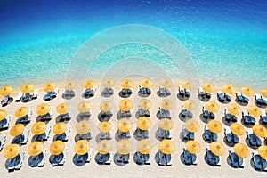 Aerial view of sea, empty sandy beach with sunbeds and umbrellas