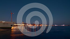 Aerial view of the sea pier of an ancient city. Action. Late evening with a pier in lights. sailing ships, time lapse