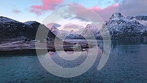 Aerial view of sea, snowy mountains, rorbuer in winter at sunrise