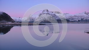 Aerial view of sea, snowy mountains, rorbuer in winter at sunrise