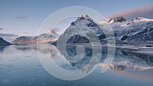 Aerial view of sea, snowy mountains, rorbuer in winter at sunrise