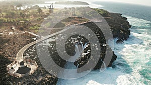 Aerial view of sea with waves crushing over Nusa Dua cliffs in Bali