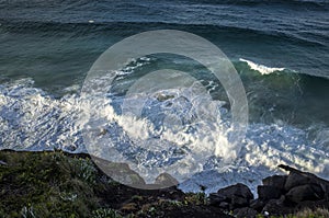 Aerial view of sea waves and dark blue beach