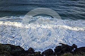 Aerial view of sea waves and dark blue beach