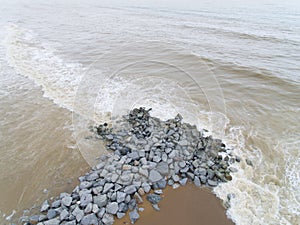 Aerial view of sea waves hitting rocks on the beach in Pantai cahaya bulan photo