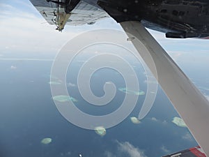 Aerial view from a seaplane window above Maldives atoll.