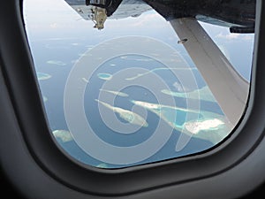 Aerial view from a seaplane window above Maldives atoll.