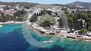 Aerial view of the seascape with ships and boats against the green coast with buildings in Croatia