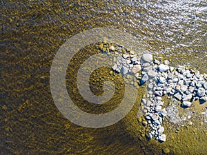 Aerial view of seashore with stone beach, lagoons and coral reefs. Coastline with sand, stone and water. Tropical landscape. Aeria