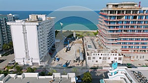 Aerial view of seaside resort with multiple hotel complexes near ocean coast. Construction site of new multi-storey