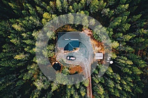 Aerial view of secluded cottage in the woods. Log cabin in the forest in rural Finland