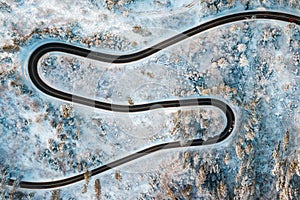 Aerial view on Serpentine in snowy winter forest. Winding road in frosty forest.