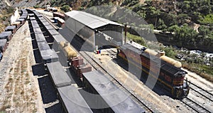 Aerial view of several railway wagon trains with goods at the railway station, Aerial view. Matucana - Peru