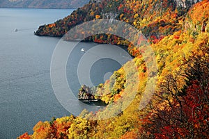 Aerial view of a sightseeing boat on autumn Lake Towada, in Towada Hachimantai National Park, Aomori, Japan