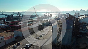 An aerial view of silos in the North Vancouver cargo terminal and trainyard with a view of downtown Vancouver.