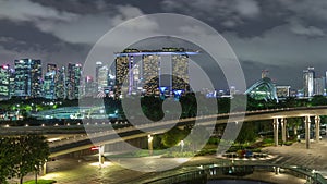 Aerial view Singapore city skyline with colorful fountain at Marina barrage garden night timelapse hyperlapse.