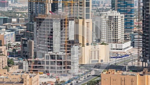 Aerial view of a skyscraper under construction with huge cranes in Dubai timelapse. United Arab Emirates