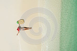 Aerial view of slim woman swimming on the transparent turquoise sea. Summer seascape with girl, beautiful waves, colorful water.