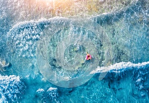 Aerial view of slim young woman swimming on the donut swim ring