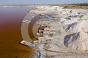Aerial view of the small boats for salt collecting at pink Lake Retba or Lac Rose in Senegal. Photo made by drone from above.