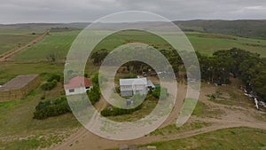 Aerial view of small farm in African countryside. Buildings and equipment surrounded by green fields. South Africa