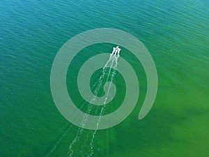 Aerial view on small fishing boat sailing straight at sea waters.