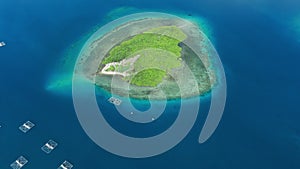 Aerial view with small island in tropics and blue ocean with boats in Indonesia.