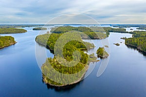 Aerial view of of small islands on a blue lake Saimaa. Landscape with drone. Blue lakes, islands and green forests from above on a