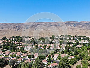 Aerial view of small neighborhood with dry desert mountain on the background in Moorpark