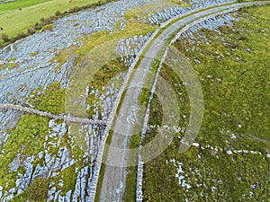 Aerial view small road in mountains, rock texture and stone fences, Burren, Ireland. Nobody