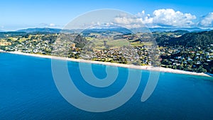 Aerial view on small suburb on a sunny ocean beach. Coromandel peninsula, New Zealand photo