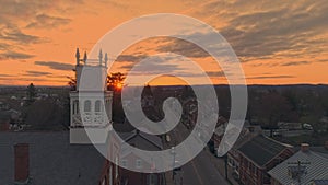 Aerial View of a Small Town and Approaching a Steeple as the Sun Breaks the Horizon on a Spring Sunrise